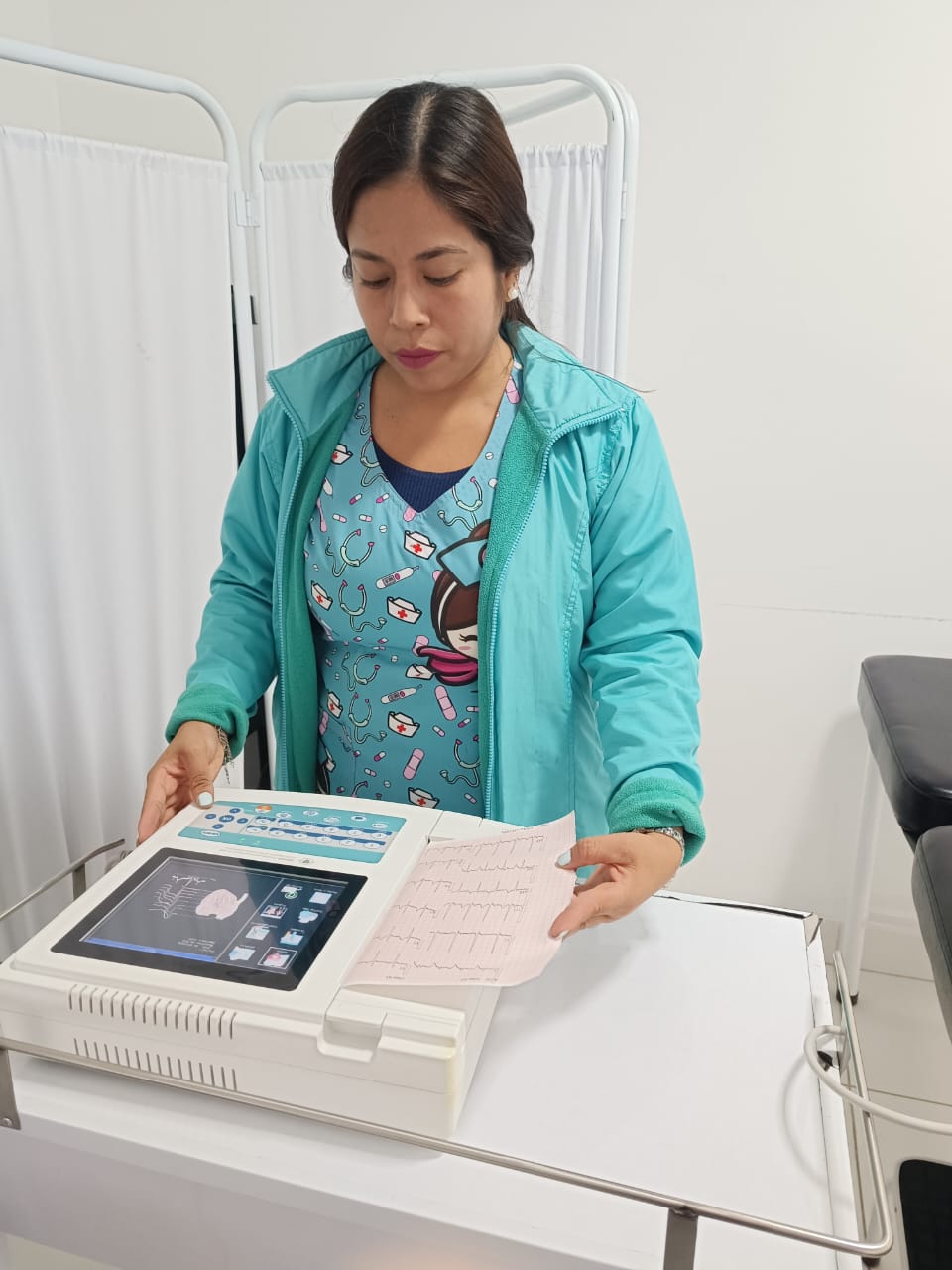 Personal de enfermería operando electrocardiógrafo